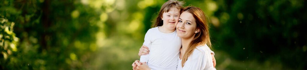 Woman and girl with downs syndrome cuddling