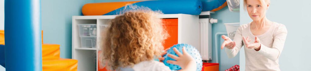 Occupational therapist works with child and ball