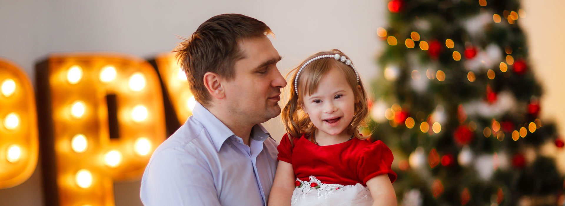 image: father and child with christmas tree