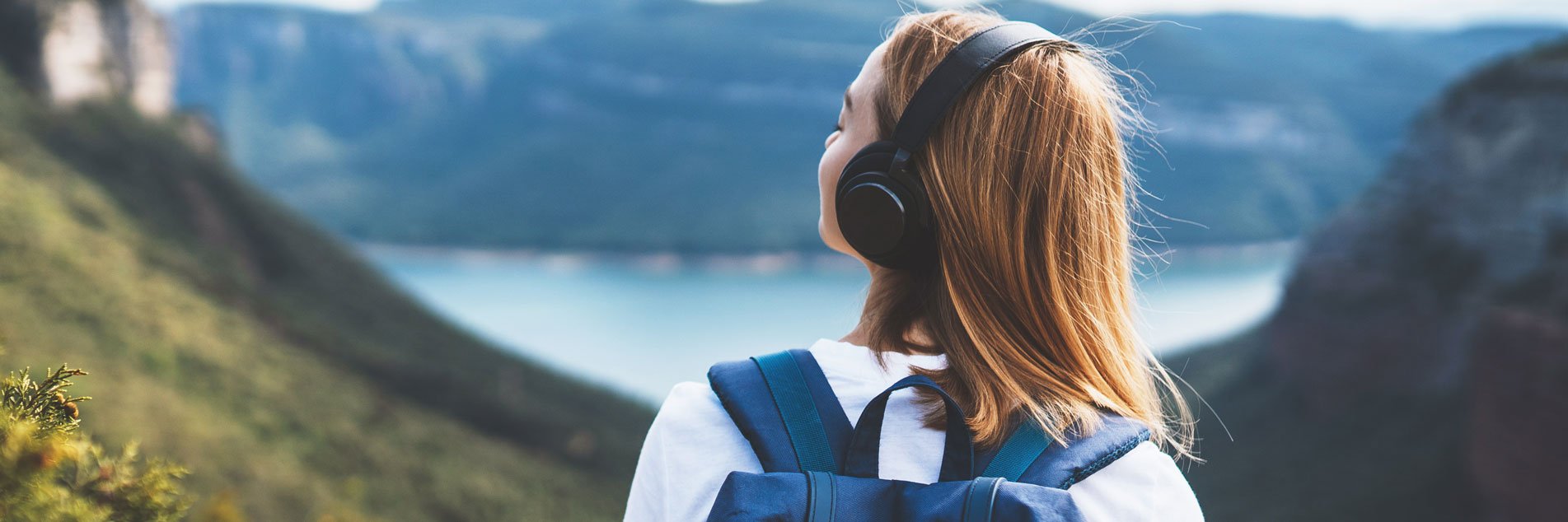 image: woman with backpack meditating listen to music with headphones